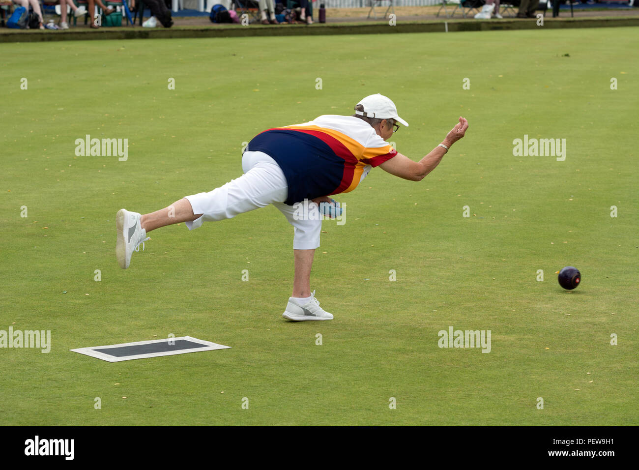 A player bowling a wood at the national women`s lawn bowls
